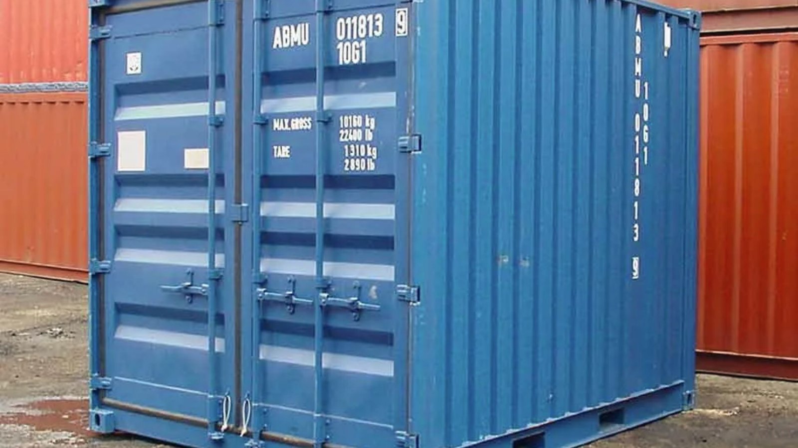 Small blue 10ft shipping container with closed double doors between larger red containers
