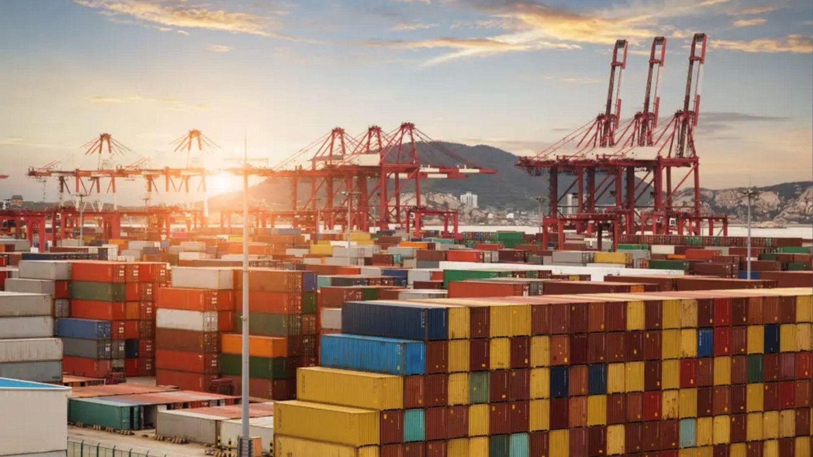 Busy container terminal at sunset with cranes, showing commodity storage before global shipping.