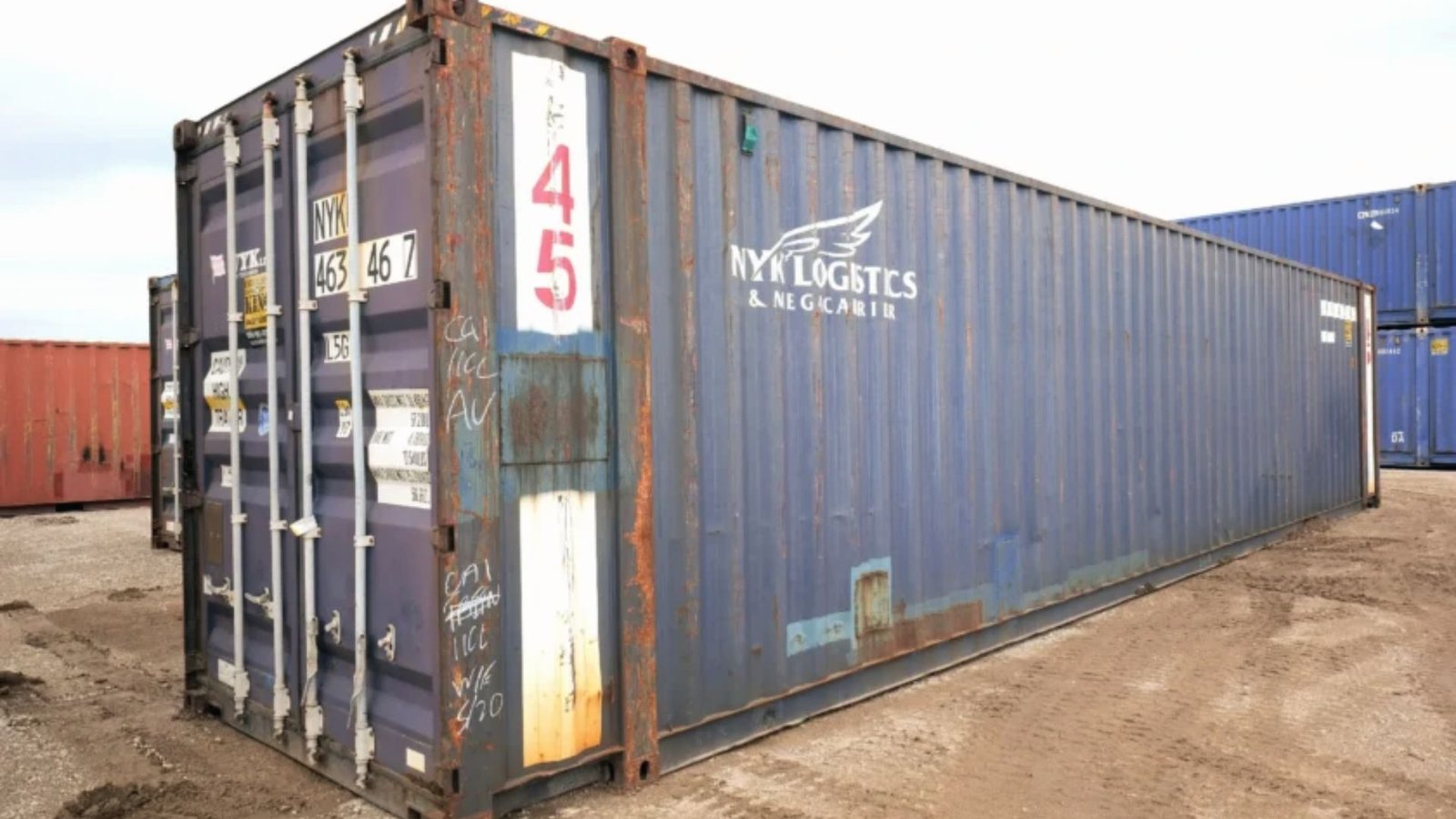 Weathered blue 45ft high cube container with NYK Logistics branding in a container yard.